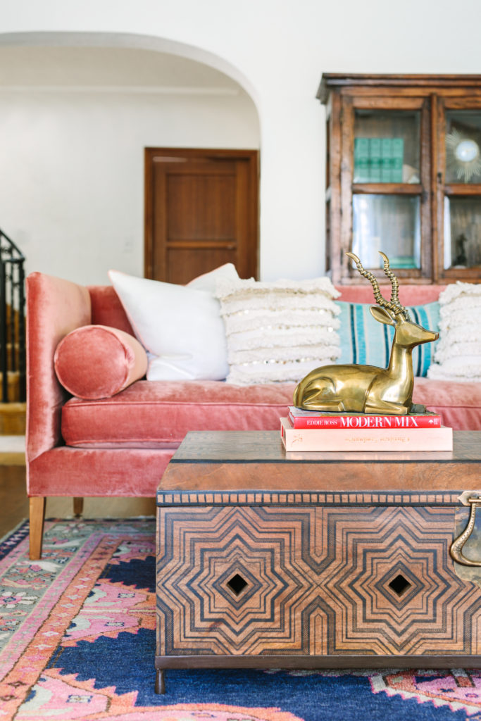 How to Achieve the Casual Glamour Look mixing rustic wood coffee table with pink sofa Caitlin Wilson kismet rug in living room