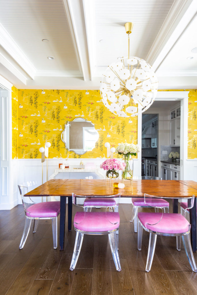 How to Achieve the Casual Glamour Look mixing rustic wood with lucite chairs Nina Campbell swan lake wallpaper yellow and pink dining room Worlds Away Duke chair 